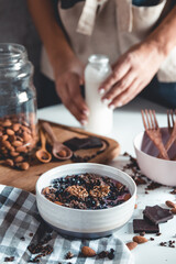 Ideas for an autumn winter breakfast. Spicy yoghurt with granola, dried berries, nuts, almonds, spices (cinnamon, anise), in cup, plate.
