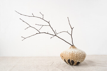 Handmade ceramics in the style of wabi sabi. Brown clay vase with an abstract pattern.