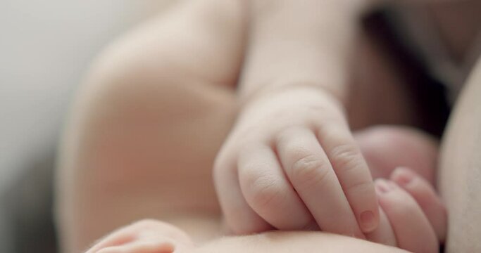 Tiny hands of newborn baby. Real time of crop infant baby moving with small fingers and faceless mother calming during sleep