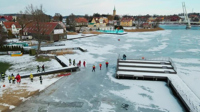 Bird's Eye View Of Rescuers Gather At Frozen Talty Lake During Ice Rescue Training In Poland. - aerial