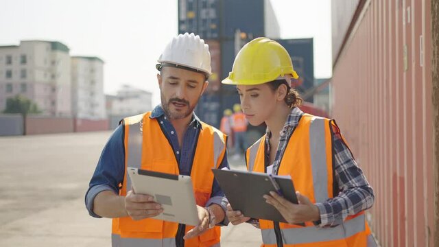 Professional industry worker of logistic concept.Engineer or foreman control loading Containers box from Cargo freight ship for import export,Engineer worker checking quantity of product in containers