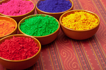 Happy Holi - bowls of organic gulal powder. Top view and copy space. Holi concept.