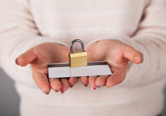 Obraz premium Padlock in a woman's hand, and credit card.