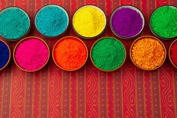 Happy Holi - bowls of organic gulal powder. Top view and copy space. Holi concept.