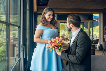 Beautiful smiling woman and man holding flowers