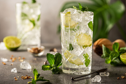 Detox fruit infused flavored water with crush ice cubes. Refreshing summer homemade cocktail with mint and lime. Healthy beverage concept