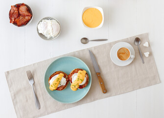 Eggs Benedict, English muffins, grilled ham, poached eggs, Hollandaise sauce, chive herbs, lemon,...