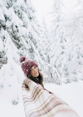 Fototapeta na wymiar Young happy girl enjoys winter, frosty day, snow, on the background of a snow-covered landscape.The winter lifestyle.Individual winter adventures.Rest during the Christmas holidays.healthy break