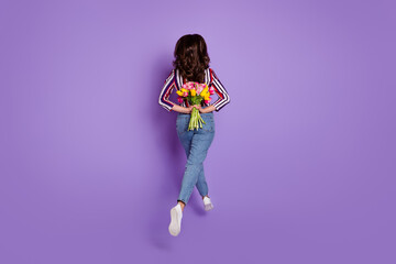 Rare view full length body size photo of woman jumping running holding tulips isolated vibrant purple color background