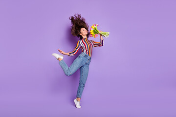 Full length body size photo of woman jumping gracefully smelling scent of flowers smiling isolated...