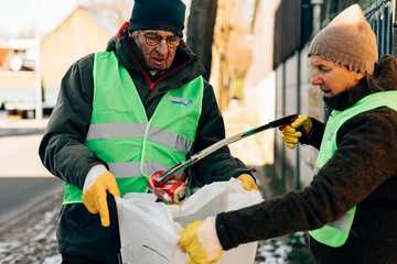 retired people collecting garbage in the street. volunteer service and sustainability lifestyle concept.