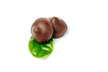 Chocolate candies decorated with a green leaf isolated on a white