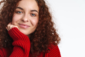 Joyful redhead curly girl smiling and looking at camera