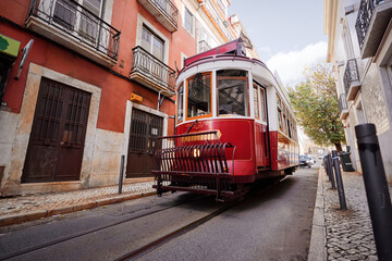 Plakat Travel by Portugal. Red old tramway on the street of Lisbon.