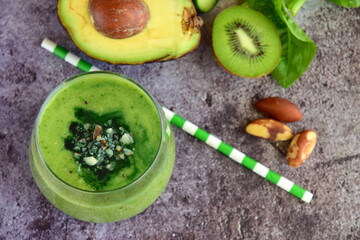 Healthy green smoothie with spinach, avocado, cucumber, pear, kiwi, spirulina and brazil nuts