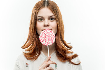 pretty woman with lollipop in hands sweets enjoyment light background