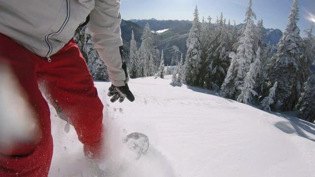 Man Freeride Snowboarding Fresh Powder Snow on Sunny Winter Day