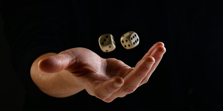 Female hand throwing dice in the air on black background. Fortune concept playing dice. luck concept. lucky man