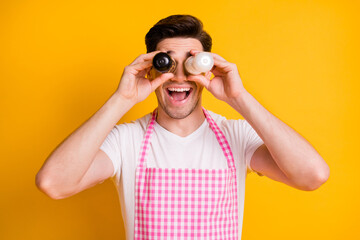Photo of crazy positive man open mouth smile arms hold salt pepper covering eyes isolated on yellow color background