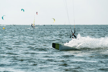 People swim in the sea on a kiteboard or kitesurfing. Summer sport learning how to kitesurf. Kite surfing on Puck bay in Jastarnia, Poland