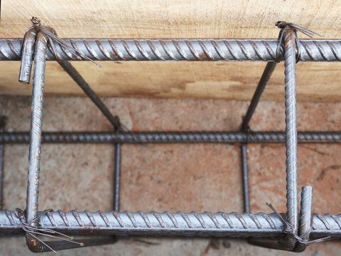 Reinforced bar (rebar). TMT steel rods tied together forming the core of concrete, enclosed in wooden mold.