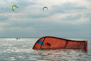 People swim in the sea on a kiteboard or kitesurfing. Summer sport learning how to kitesurf. Kite surfing on Puck bay in Jastarnia, Poland