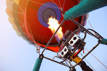 A hot air balloon is raised with flames burning from a gas stove or propane stove equipment.