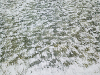 Frosty patterns on ice. Aerial drone view. Foggy winter morning.