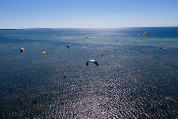 People swim in the sea on a kiteboard or kitesurfing. Summer sport learning how to kitesurf. Kite...