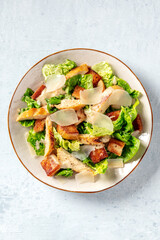 Caesar salad with grilled chicken, romaine and Parmesan cheese, shot from above
