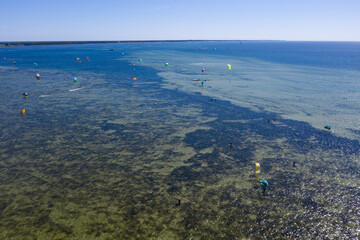 People swim in the sea on a kiteboard or kitesurfing. Summer sport learning how to kitesurf. Kite...