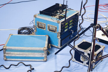 Backstage and tech zone with rack amplifiers, audio signal splitters, patch panels, radio microphone systems and flight cases. Professional sound equipment for a broadcasting.