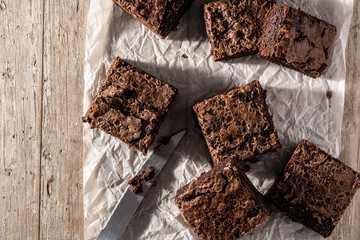 Homemade pieces of brownies on rustic wooden table. Top view