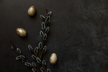 Obraz na płótnie Canvas Happy Easter concept. Preparation for holiday. Golden decorated easter eggs willow on trendy grunge scratched dark black shale background. Simple minimalism flat lay top view, copy space
