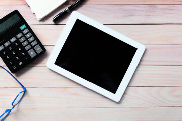 Flat composition of digital tablet and office stationary on black background 