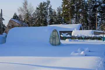 The greenhouse is covered with snow.