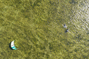 People swim in the sea on a kiteboard or kitesurfing. Summer sport learning how to kitesurf. Kite...