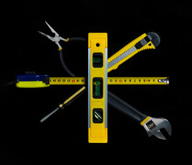 Tools for master builder on a black background. Close-up of construction tool. Top view
