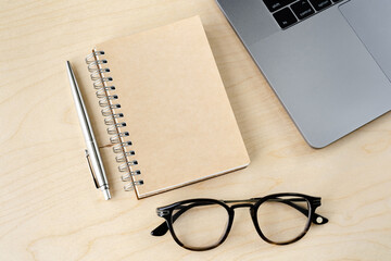 Notepad, pen, glasses and notebook on the wood table