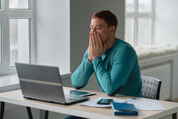 Frustrated stressed businessman at home office. businessman working on laptop computer holding head with hands looking down. Negative human emotion facial expression feelings.