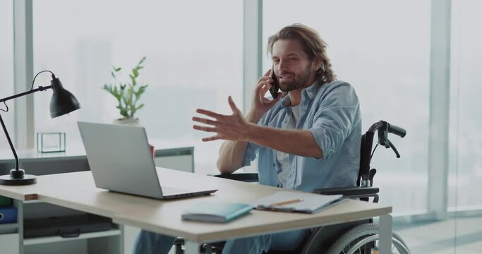 Handsome young invalid disabled man business guy talking on mobile phone in contemporary office. Worker. Person with disabilities. Phone call.