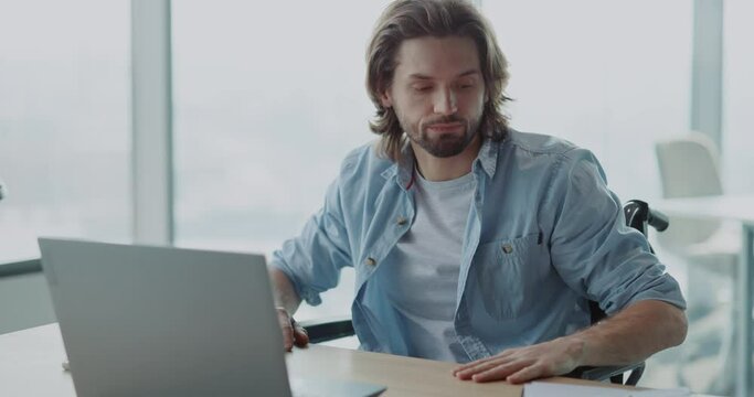 Unwell caucasian office manager male frutrsating at desk having problem with laptop worry about deadline. Work depression. Disabled worker.