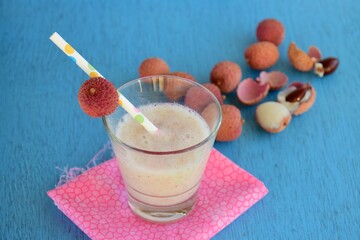 Fresh lychee juice with fruits on blue background
