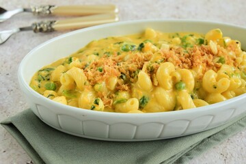 Creamy baked cavatappi pasta with sweet potato, cheddar cheese, peas and spinach garnish with panko crumbs
