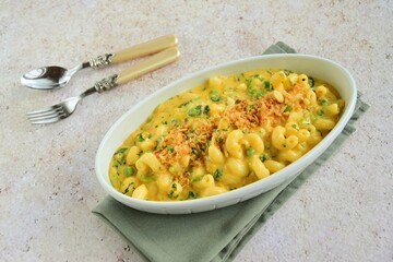 Creamy baked cavatappi pasta with sweet potato, cheddar cheese, peas and spinach garnish with panko crumbs