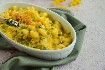 Creamy baked cavatappi pasta with sweet potato, cheddar cheese, peas and spinach garnish with panko crumbs