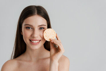 Happy shirtless nice girl smiling while posing with cleansing sponge