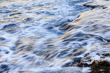 Blurred abstract natural background of sea water with waves and foam. Motion blur. Nature. 