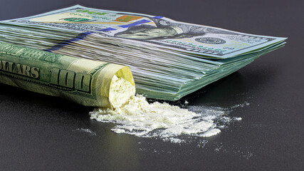 Bundle of one hundred dollar bills and drugs heroin or cocaine on a black background. The concept...