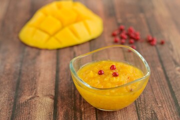 Mango pink peppercorn dressing on wooden background. Selective focus